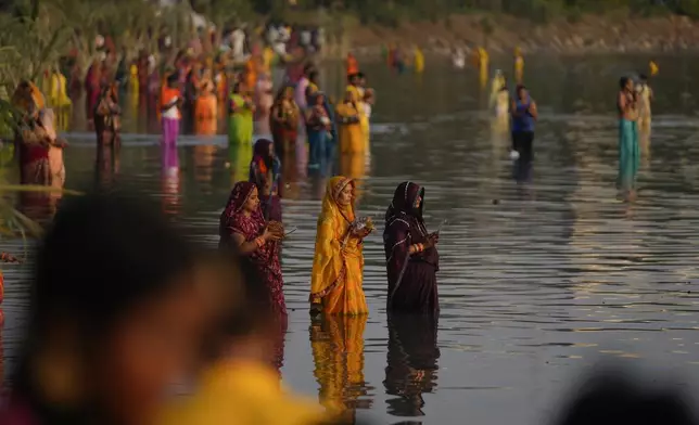 Hindu devotees pray to the sun god standing in knee deep waters in the Hussain Sagar Lake during Chhath festival in Hyderabad, India, Thursday, Nov. 7, 2024. (AP Photo/Mahesh Kumar A.)