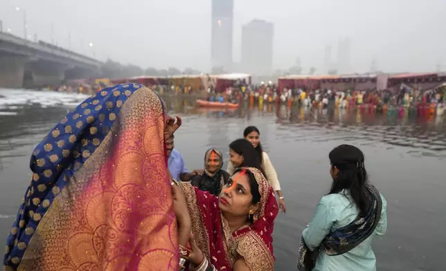 Women devotees get ready on the banks of the river Yamuna to offer prayers to the sun god during Chhath festival in Noida, near New Delhi, India, Thursday, Nov. 7, 2024. (AP Photo/Manish Swarup)