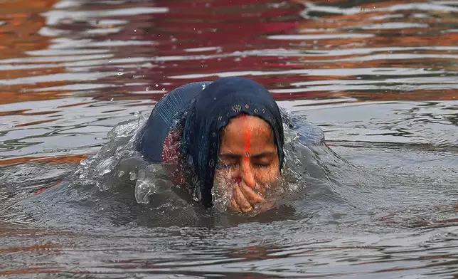 A devotee takes a dip in the river Yamuna before offering prayers to the sun god during Chhath festival in Noida, near New Delhi, India, Thursday, Nov. 7, 2024. (AP Photo/Manish Swarup)