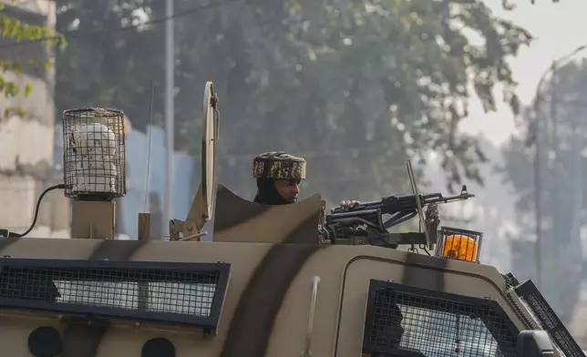 An Indian paramilitary soldier guards on top of his armored vehicle at the site of a grenade explosion at a marketplace, in Srinagar, Indian controlled Kashmir,Sunday, Nov. 3, 2024. (AP Photo/Mukhtar Khan)