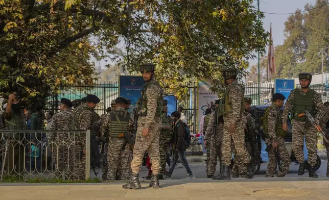 Indian paramilitary soldiers inspect the site of a grenade explosion at a marketplace in Srinagar, Indian controlled Kashmir, Sunday, Nov. 3, 2024. (AP Photo/Mukhtar Khan)