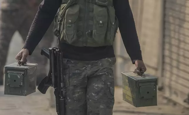 An Indian paramilitary soldier carrying ammunition boxes moves towards the site of a gun battle, in Srinagar, Indian controlled Kashmir, Saturday, Nov. 2, 2024. (AP Photo/Mukhtar Khan)