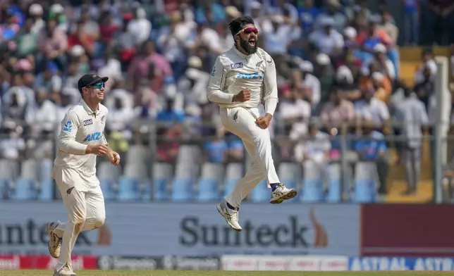 New Zealand's Aijaz Patel, right, jumps up in the air as he celebrates the wicket of India's Ravindra Jadeja during the third day of the third cricket test match between India and New Zealand at Wankhede Stadium, in Mumbai, India, Sunday, Nov. 3, 2024.(AP Photo/Rajanish Kakade)