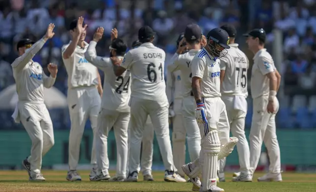 India's Virat Kohli, third right, walks off the field as New Zealand's players celebrates his dismissal during the third day of the third cricket test match between India and New Zealand at Wankhede Stadium, in Mumbai, India, Sunday, Nov. 3, 2024.(AP Photo/Rajanish Kakade)