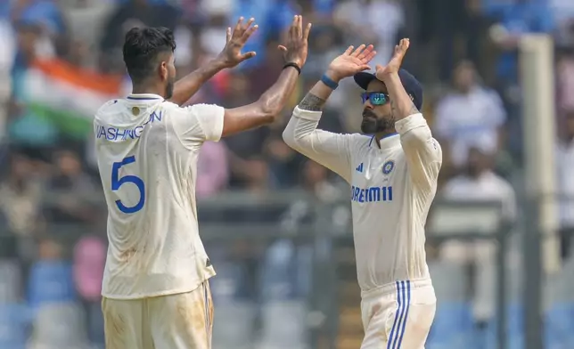 India's Washington Sundar, left, and Virat Kohli celebrates the dismissal of New Zealand's Rachin Ravindra during the first day of the third cricket test match between India and New Zealand at Wankhede Stadium, in Mumbai, India, Friday, Nov. 1, 2024.(AP Photo/Rajanish Kakade)