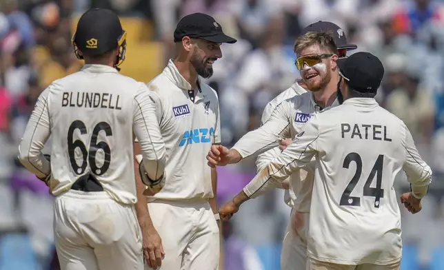 New Zealand's Glenn Phillips, second right without cap, celebrates with teammates after the dismissal of India's Akash Deep during the third day of the third cricket test match between India and New Zealand at Wankhede Stadium, in Mumbai, India, Sunday, Nov. 3, 2024.(AP Photo/Rajanish Kakade)