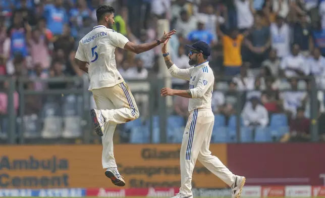 India's Washington Sundar, left, and Virat Kohli celebrates the dismissal of New Zealand's captain Tom Latham during the first day of the third cricket test match between India and New Zealand at Wankhede Stadium, in Mumbai, India, Friday, Nov. 1, 2024.(AP Photo/Rajanish Kakade)