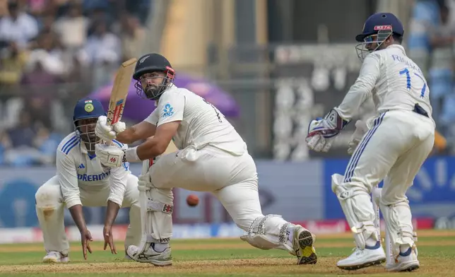 New Zealand's Daryl Mitchell watches at the ball after playing a shot during the first day of the third cricket test match between India and New Zealand at Wankhede Stadium, in Mumbai, India, Friday, Nov. 1, 2024.(AP Photo/Rajanish Kakade)