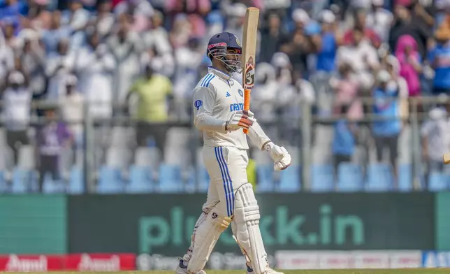 India's Rishab Pant raises his bat as he celebrates after scoring fifty runs during the third day of the third cricket test match between India and New Zealand at Wankhede Stadium, in Mumbai, India, Sunday, Nov. 3, 2024.(AP Photo/Rajanish Kakade)