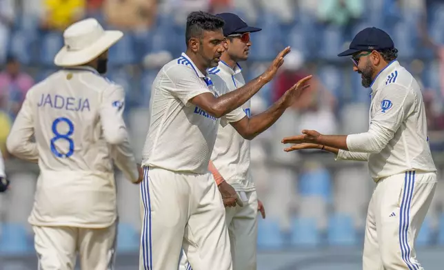 India's Ravichandran Ashwin, center, celebrates with teammates after the dismissal of New Zealand's Rachin Ravindra during the second day of the third cricket test match between India and New Zealand at Wankhede Stadium, in Mumbai, India, Saturday, Nov. 2, 2024.(AP Photo/Rajanish Kakade)