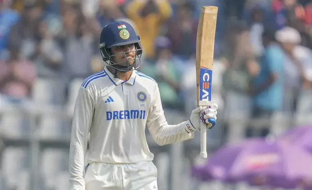 India's Shubman Gill raises his bat as he celebrates after scoring fifty runs during the second day of the third cricket test match between India and New Zealand at Wankhede Stadium, in Mumbai, India, Saturday, Nov. 2, 2024.(AP Photo/Rajanish Kakade)