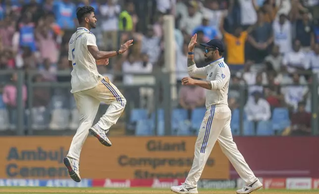 India's Washington Sundar, left, and Virat Kohli celebrates the dismissal of New Zealand's captain Tom Latham during the first day of the third cricket test match between India and New Zealand at Wankhede Stadium, in Mumbai, India, Friday, Nov. 1, 2024.(AP Photo/Rajanish Kakade)