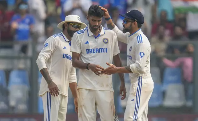 Washington Sundar, center, Virat Kohli, right, and Ravindra Jadeja celebrates the dismissal of New Zealand's captain Tom Latham during the first day of the third cricket test match between India and New Zealand at Wankhede Stadium, in Mumbai, India, Friday, Nov. 1, 2024.(AP Photo/Rajanish Kakade)