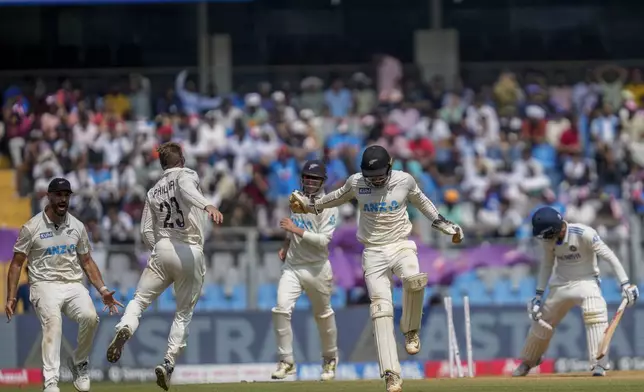 New Zealand's Glenn Phillips, second left, celebrates with teammates after the dismissal of India's Akash Deep, right, during the third day of the third cricket test match between India and New Zealand at Wankhede Stadium, in Mumbai, India, Sunday, Nov. 3, 2024.(AP Photo/Rajanish Kakade)