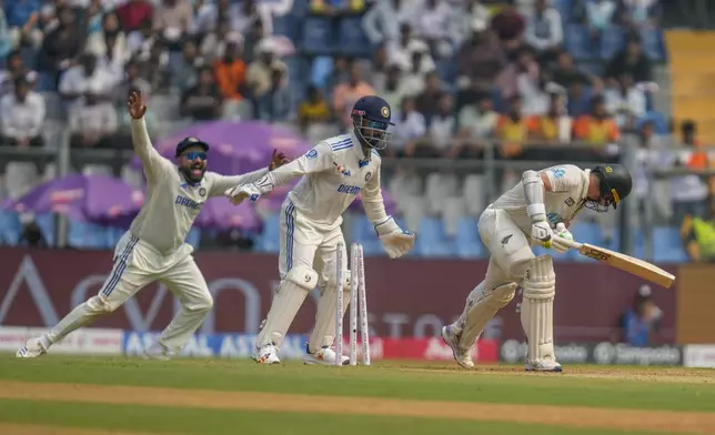 India's captain Rohit Sharma, left, Rishab Pant, center, celebrates the dismissal of New Zealand's captain Tom Latham, right, during the first day of the third cricket test match between India and New Zealand at Wankhede Stadium, in Mumbai, India, Friday, Nov. 1, 2024.(AP Photo/Rajanish Kakade)