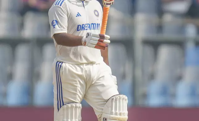 India's Rishab Pant raises his bat as he celebrates after scoring fifty runs during the second day of the third cricket test match between India and New Zealand at Wankhede Stadium, in Mumbai, India, Saturday, Nov. 2, 2024.(AP Photo/Rajanish Kakade)