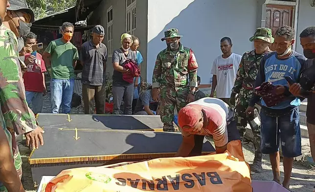 Indonesian soldiers and residents put the body of a victim into a coffin for burial following the eruption of Mount Lewotobi Laki-Laki in East Flores, Indonesia, Monday, Nov. 4, 2024. (AP Photo)