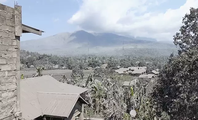 In this image made from AP video, Mount Lewotobi Lake-Laki spews volcanic smoke as village affected by its eruption is seen in the foreground in East Flores, Indonesia, Tuesday, Nov. 5, 2024. (AP Photo)