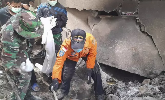 In this photo released by the Indonesian National Search and Rescue Agency (BASARNAS), rescuers search for victims of the eruption of Mount Lewotobi Laki-Laki in East Flores, Indonesia on Monday, Nov. 4, 2024. (BASARNAS via AP)