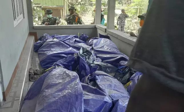 In this photo released by the Indonesian National Search and Rescue Agency (BASARNAS), rescuers inspect the bodies of the victims of the eruption of Mount Lewotobi Laki-Laki in East Flores, Indonesia on Monday, Nov. 4, 2024. (BASARNAS via AP)