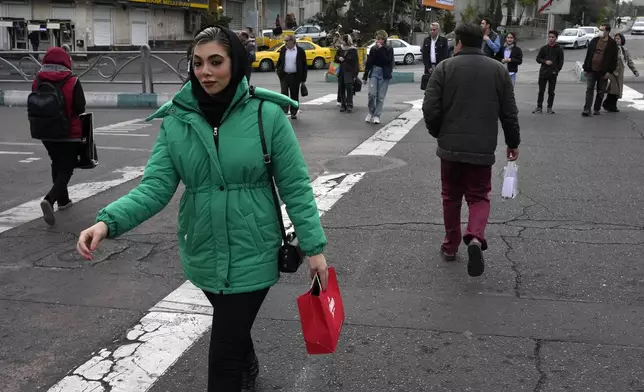 People cross an intersection in northern Tehran, Iran, Thursday, Nov. 7, 2024. (AP Photo/Vahid Salemi)