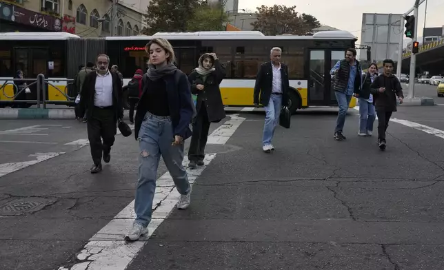 People cross an intersection in northern Tehran, Iran, Thursday, Nov. 7, 2024. (AP Photo/Vahid Salemi)