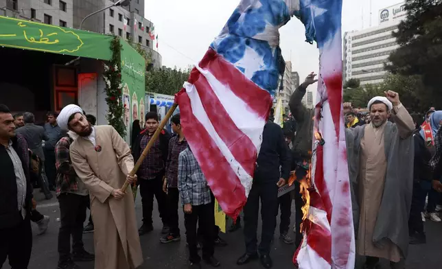 Iranian demonstrators burn a representation of the U.S. flag in an annual rally in front of the former U.S. Embassy in Tehran, Iran, Sunday, Nov. 3, 2024, marking the 45th anniversary of Iranian students' takeover of the embassy, starting a hostage crisis. (AP Photo/Vahid Salemi)