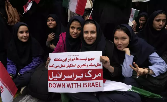 An Iranian schoolgirl holds an anti-Israeli placard during an annual rally in front of the former U.S. Embassy in Tehran, Iran, Sunday, Nov. 3, 2024, marking the 45th anniversary of Iranian students' takeover of the embassy, starting a hostage crisis. (AP Photo/Vahid Salemi)