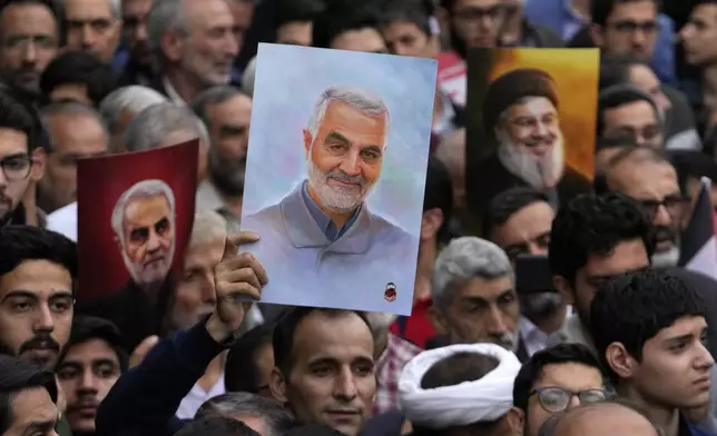 Iranian demonstrators hold up posters of the late Revolutionary Guard Gen. Qassem Soleimani, center and left, who was killed in Iraq in a U.S. drone attack in 2020, and the late Hezbollah leader Hassan Nasrallah, who was killed in an Israeli airstrike in Beirut in September, during an annual rally in front of the former U.S. Embassy in Tehran, Iran, Sunday, Nov. 3, 2024, marking the 45th anniversary of Iranian students' takeover of the embassy, starting a hostage crisis. (AP Photo/Vahid Salemi)