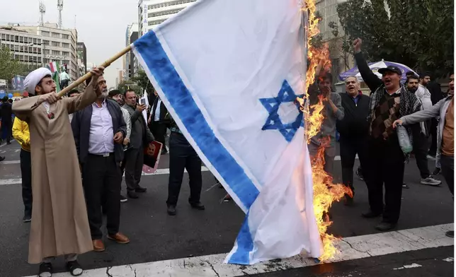 Iranian demonstrators burn a representation of the Israeli flag in an annual rally in front of the former U.S. Embassy in Tehran, Iran, Sunday, Nov. 3, 2024, marking the 45th anniversary of Iranian students' takeover of the embassy, starting a hostage crisis. (AP Photo/Vahid Salemi)