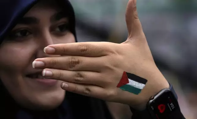 A woman shows her hand painted with the Palestinian flag in an annual rally in front of the former U.S. Embassy in Tehran, Iran, Sunday, Nov. 3, 2024, marking the 45th anniversary of Iranian students' takeover of the embassy, starting a hostage crisis. (AP Photo/Vahid Salemi)