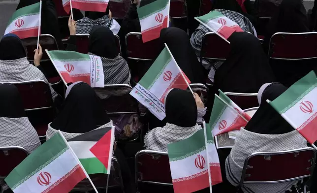 Demonstrators wave Iranian and Palestinian flags in an annual rally in front of the former U.S. Embassy in Tehran, Iran, Sunday, Nov. 3, 2024, marking the 45th anniversary of Iranian students' takeover of the embassy, starting a hostage crisis. (AP Photo/Vahid Salemi)