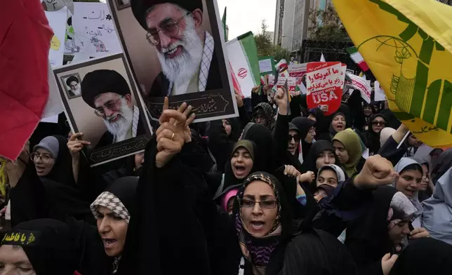 Holding posters of the Iranian Supreme Leader Ayatollah Ali Khamenei and Lebanon's Hezbollah flag, demonstrators chant slogans in an annual rally in front of the former U.S. Embassy in Tehran, Iran, Sunday, Nov. 3, 2024, marking the 45th anniversary of Iranian students' takeover of the embassy, starting a hostage crisis. (AP Photo/Vahid Salemi)