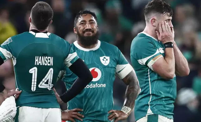 Ireland's Bundee Aki, centre smiles at teammate Ireland's Mack Hansen, at the end of the Autumn Nations series rugby union match between Ireland and New Zealand at the Aviva Stadium in Dublin, Ireland , Friday, Nov. 8, 2024. New Zealand won the game 23-13. (AP Photo/Peter Morrison)