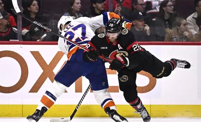 Ottawa Senators right wing Claude Giroux (28) tries to knock the puck away from New York Islanders left wing Anders Lee (27) during second period NHL hockey action in Ottawa, on Thursday, Nov. 7, 2024. (Justin Tang/The Canadian Press via AP)