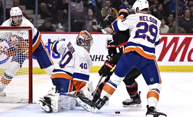 New York Islanders centre Brock Nelson (29) keeps Ottawa Senators left wing Brady Tkachuk (7) from getting a shot on goaltender Semyon Varlamov (40) during second period NHL hockey action in Ottawa, on Thursday, Nov. 7, 2024. (Justin Tang/The Canadian Press via AP)