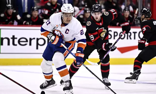 New York Islanders left wing Anders Lee (27) skates the puck past Ottawa Senators right wing Drake Batherson (19) during first period NHL hockey action in Ottawa, on Thursday, Nov. 7, 2024. (Justin Tang/The Canadian Press via AP)