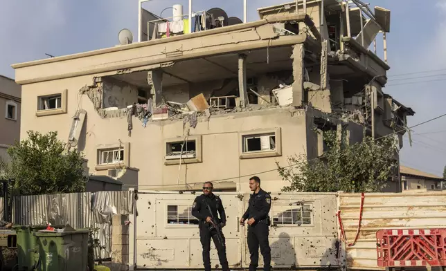 Israeli police men work at the site where projectiles fired from Lebanon hit a home in Tira, central Israel, Saturday, Nov. 2, 2024. (AP Photo/Ariel Schalit)