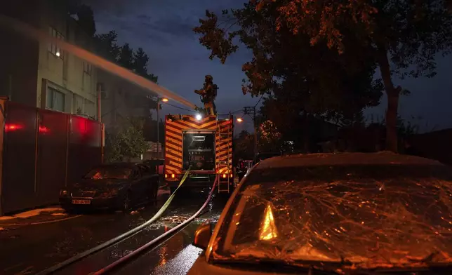 Firefighters work to extinguish a fire after a rocket fired from Lebanon hit Kiryat Ata, northern Israel, on Monday, Nov. 11, 2024. (AP Photo/Francisco Seco)