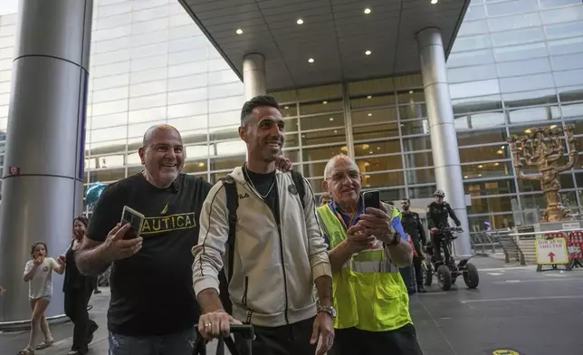 Eran Zahavi of Maccabi Tel Aviv, center, arrives at Israel's Ben-Gurion International Airport on a flight from Amsterdam, where Israeli soccer fans were attacked following a match between the Israeli club and Ajax Amsterdam, in Lod, Israel, Friday, Nov. 8, 2024. (AP Photo/Tsafrir Abayov)