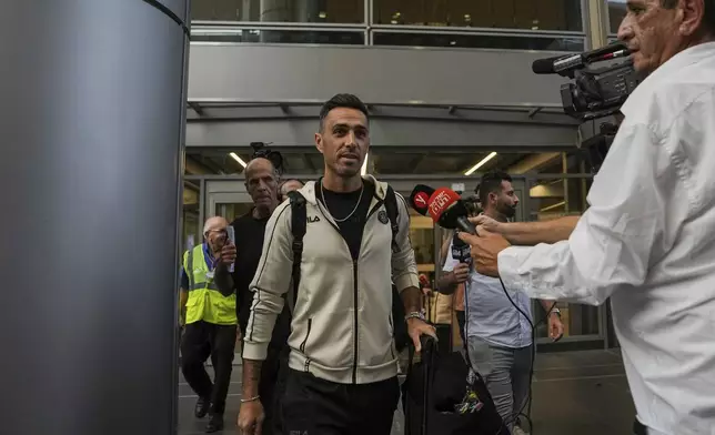 Eran Zahavi of Maccabi Tel Aviv, center, arrives at Israel's Ben-Gurion International Airport on a flight from Amsterdam, where Israeli soccer fans were attacked following a match between the Israeli club and Ajax Amsterdam, in Lod, Israel, Friday, Nov. 8, 2024. (AP Photo/Tsafrir Abayov)