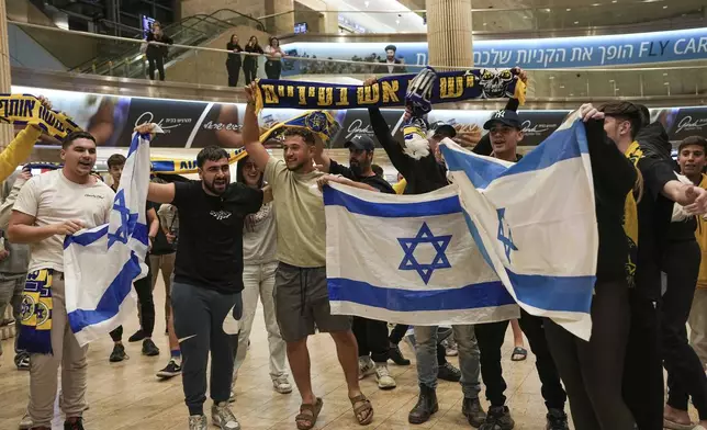 People welcome Maccabi Tel Aviv soccer fans as they arrive at Israel's Ben-Gurion International Airport on a flight from Amsterdam, where Israeli soccer fans were attacked following a match between the Israeli club and Ajax Amsterdam, in Lod, Israel, Friday, Nov. 8, 2024. (AP Photo/Tsafrir Abayov)