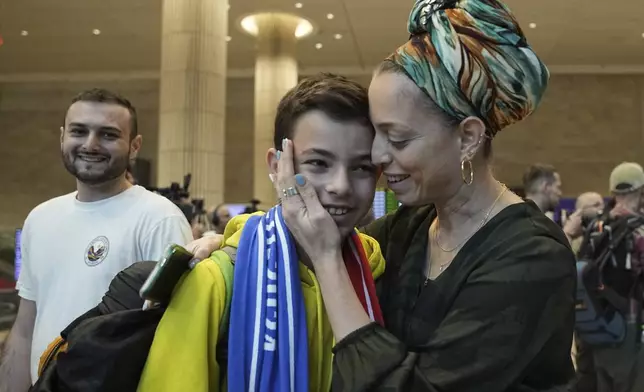 A woman embraces her son, who is a fan of Maccabi Tel Aviv, as he arrives at Israel's Ben-Gurion International Airport on a flight from Amsterdam, where Israeli soccer fans were attacked following a match between the Israeli club and Ajax Amsterdam in Lod, Israel, Friday, Nov. 8, 2024. (AP Photo/Tsafrir Abayov)