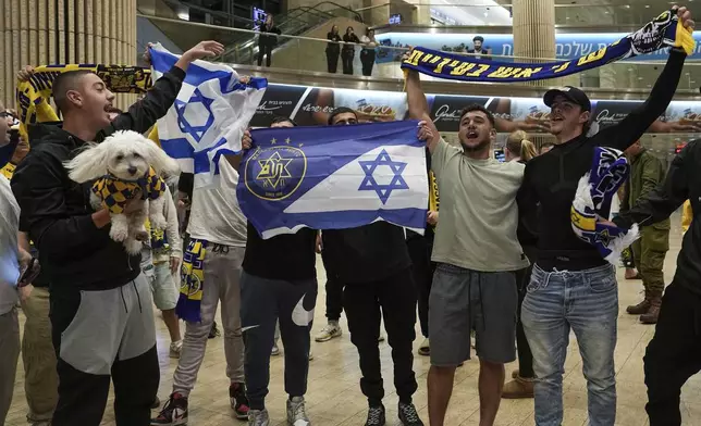 People welcome Maccabi Tel Aviv soccer fans as they arrive at Israel's Ben-Gurion International Airport on a flight from Amsterdam, where Israeli soccer fans were attacked following a match between the Israeli club and Ajax Amsterdam, in Lod, Israel, Friday, Nov. 8, 2024. (AP Photo/Tsafrir Abayov)