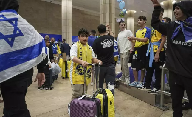 People welcome Maccabi Tel Aviv soccer fans as they arrive at Israel's Ben-Gurion International Airport on a flight from Amsterdam, where Israeli soccer fans were attacked following a match between the Israeli club and Ajax Amsterdam, in Lod, Israel, Friday, Nov. 8, 2024. (AP Photo/Tsafrir Abayov)