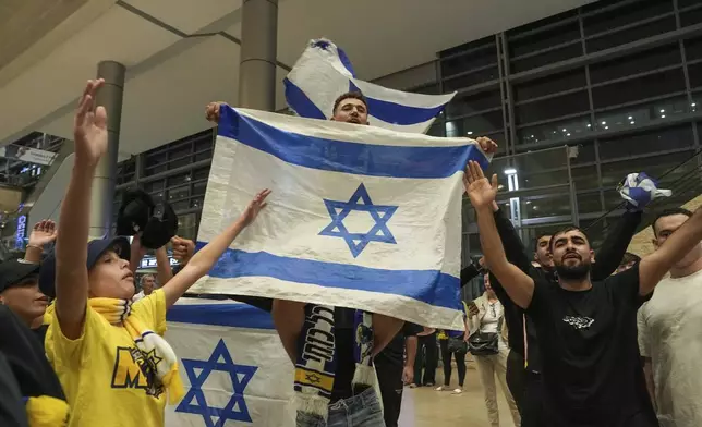 People welcome Maccabi Tel Aviv soccer fans as they arrive at Israel's Ben-Gurion International Airport on a flight from Amsterdam, where Israeli soccer fans were attacked following a match between the Israeli club and Ajax Amsterdam, in Lod, Israel, Friday, Nov. 8, 2024. (AP Photo/Tsafrir Abayov)