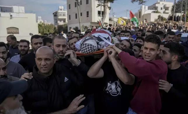 Mourners carry the body of Naji al-Baba,16, who the Palestinian Health Ministry said was killed by Israeli forces in the town of Halhul, West Bank, during his funeral on Monday, Nov. 4, 2024. (AP Photo/Mahmoud Illean)