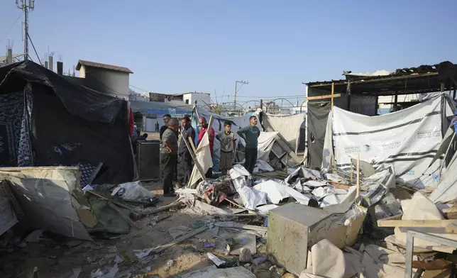 Palestinians gather at the site of an Israeli strike in the courtyard of the Al-Aqsa Hospital where displaced people live in tents, in Deir al-Balah, Gaza Strip, Saturday, Nov. 9, 2024. (AP Photo/Abdel Kareem Hana)