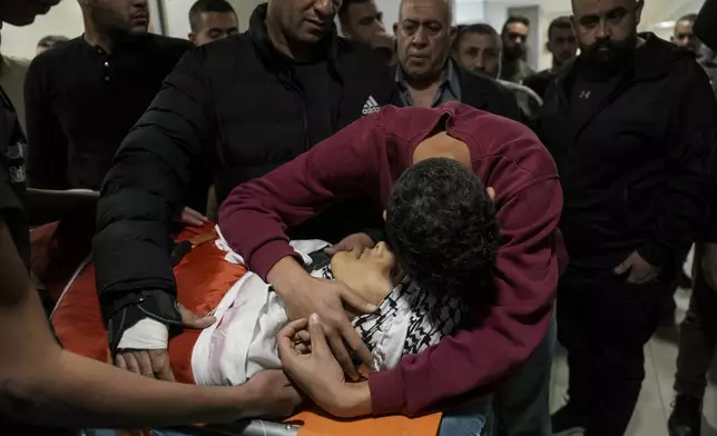 Palestinians mourn over the body of Naji al-Baba,16, who the Palestinian Health Ministry said was killed by Israeli forces in the town of Halhul, West Bank, during his funeral on Monday, Nov. 4, 2024. (AP Photo/Mahmoud Illean)