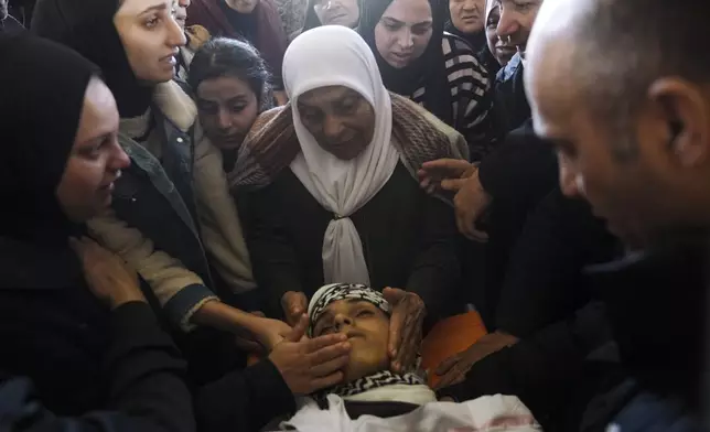 Palestinians mourn over the body of Naji al-Baba,16, who the Palestinian Health Ministry said was killed by Israeli forces in the town of Halhul, West Bank, during his funeral on Monday, Nov. 4, 2024. (AP Photo/Mahmoud Illean)